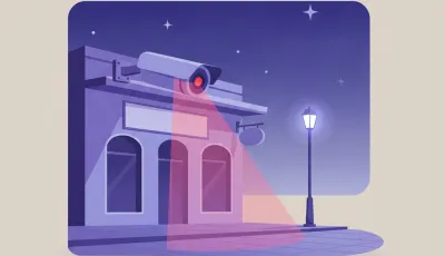 Ilustración de una cámara de seguridad exterior montada bajo el alero de un local, con luz infrarroja encendida apuntando a la vereda de noche